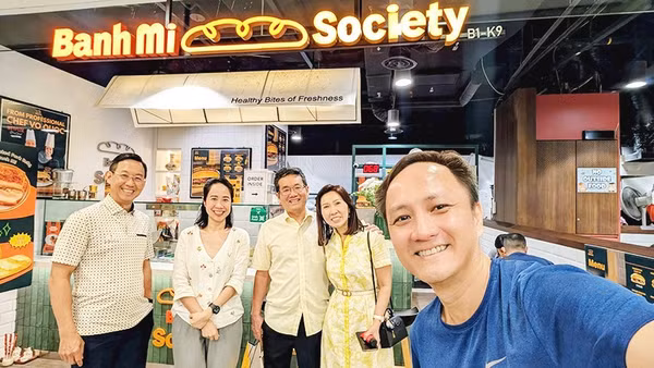 Chị Quỳnh (thứ hai, trái sang) tại tiệm bánh mì Việt Nam ở Singapore.