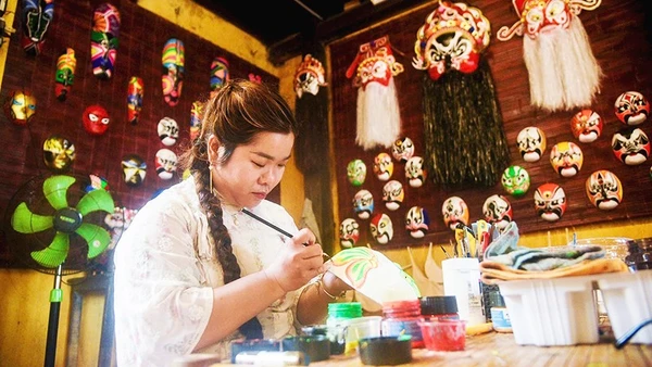 Huyền Trang vẽ mặt nạ tại không gian trưng bày và trải nghiệm của gia đình.