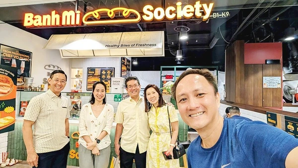 Chị Quỳnh (thứ hai, trái sang) tại tiệm bánh mì Việt Nam ở Singapore.