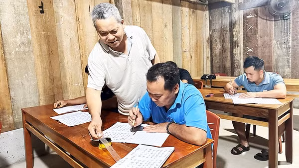 Thầy Chư tận tình hướng dẫn học viên viết chữ Nôm Dao.