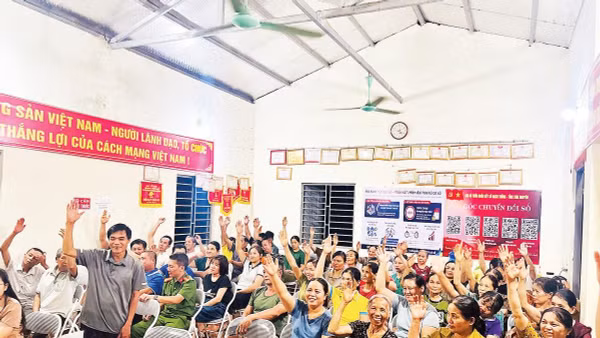 Đại diện các hộ gia đình thôn Đoàn Kết, xã Bạch Thông biểu quyết nhất trí phương án sắp xếp, tổ chức lại thôn, bản (Ảnh MINH NGUYỆT)
