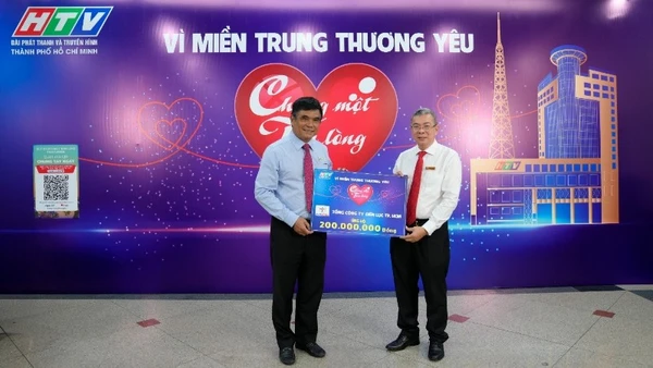 Ông Nguyễn Văn Thanh, Tổng Giám đốc EVNHCMC (áo trắng) trao bảng tượng trưng số tiền 200 triệu ủng hộ Quỹ “Chung một tấm lòng: Vì miền trung thương yêu”.