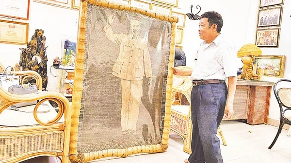 Nghệ nhân nhân dân Nguyễn Văn Trung bên bức chân dung Bác Hồ bằng mây tre vừa hoàn thiện.