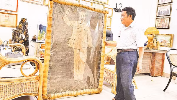 Nghệ nhân nhân dân Nguyễn Văn Trung bên bức chân dung Bác Hồ bằng mây tre vừa hoàn thiện.