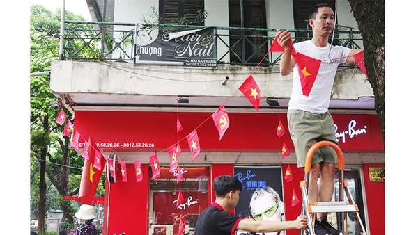 Người dân phường Hoàn Kiếm treo cờ đỏ sao vàng đón ngày đại lễ. Ảnh: ANH QUÂN