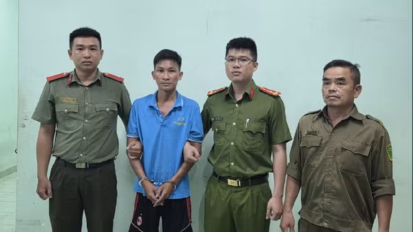 Đối tượng Bùi Trung Quốc (áo xanh) tại Cơ quan Công an. (Ảnh: Công an cung cấp)