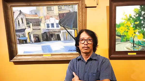 Họa sĩ Bùi Lê Dũng bên tác phẩm của mình.