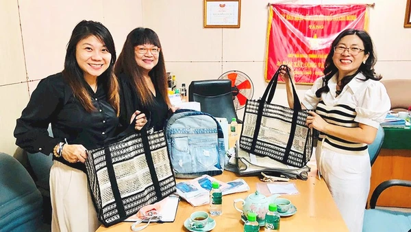 Chị Kim Bình (bên phải) giới thiệu sản phẩm túi lưới tái chế với khách hàng.