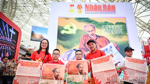 Niềm vui của một gia đình nhỏ khi xếp hàng và nhận được phụ san đặc biệt Báo Nhân Dân. Ảnh: THÀNH ĐẠT