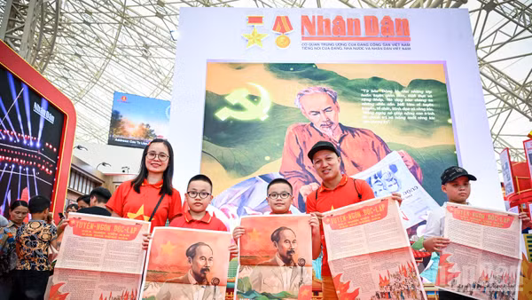 Niềm vui của một gia đình nhỏ khi xếp hàng và nhận được phụ san đặc biệt Báo Nhân Dân. Ảnh: THÀNH ĐẠT