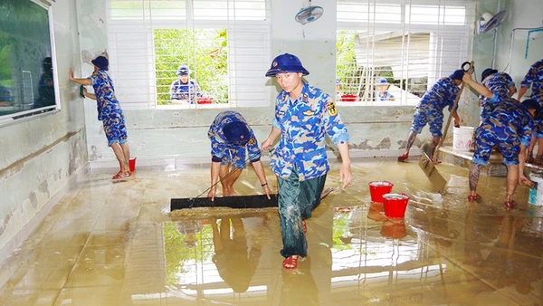 Kéo bùn dọn dẹp phòng học. Ảnh: HẢI LUẬN