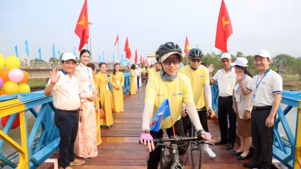 Các vận động viên đạp xe diễu hành qua cầu Hiền Lương.
