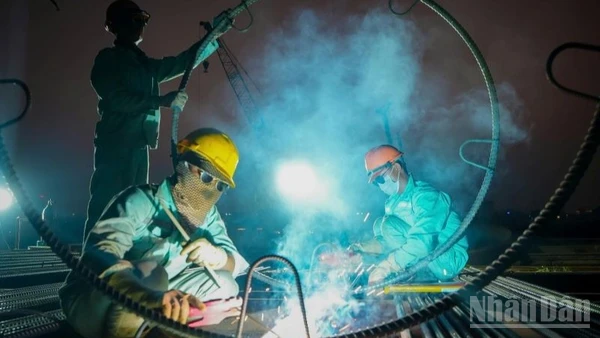 Những ngày cận Tết Nguyên đán, ngày cũng như đêm, trên công trường xây dựng cầu Trần Hưng Đạo (Hà Nội), nhịp độ lao động vẫn hết sức sôi động, khẩn trương.