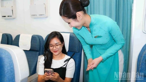Tiếp viên Vietnam Airlines hướng dẫn hành khách sử dụng internet trên chuyến bay.