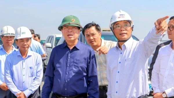 Lãnh đạo Ban Quản lý dự án Mỹ Thuận báo cáo tiến độ dự án cùng với Bộ trưởng Xây dựng Trần Hồng Minh (áo xanh đậm) tại hiện trường.