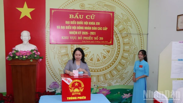 Đồng chí Võ Thị Ánh Xuân đại diện cử tri tiêu biểu của địa phương bỏ những lá phiếu đầu tiên vào thùng phiếu.