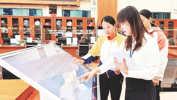 Cán bộ hướng dẫn người dân làm thủ tục hành chính tại bộ phận một cửa.