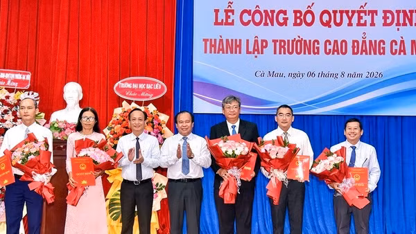 Phó Bí thư Tỉnh ủy, Chủ tịch Hội đồng nhân dân tỉnh Phạm Văn Thiều (bên trái) và Phó Chủ tịch Ủy ban nhân dân tỉnh Nguyễn Minh Luân trao quyết định, tặng hoa chúc mừng các đồng chí được bổ nhiệm giữ chức Hiệu trưởng, Phó Hiệu trưởng Trường cao đẳng Cà Mau. (Ảnh: CTV)