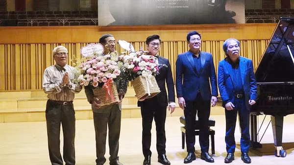Đại sứ Nguyễn Thạc Dĩnh, đại sứ Nguyễn Phú Bình (từ trái sang) và nhà thơ Nguyễn Quang Thiều, TS, NSND Đỗ Quốc Hưng (từ phải sang) tặng hoa nghệ sĩ Lưu Hồng Quang sau màn trình diễn. Ảnh: NGUYỄN ĐÌNH TOÁN