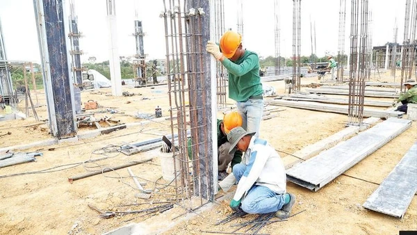 Các công nhân dựng trụ đổ bê-tông.