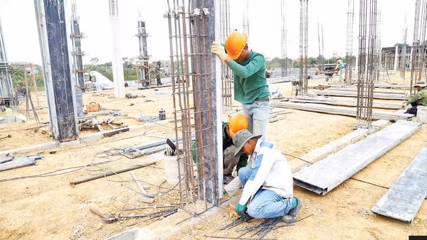 Các công nhân dựng trụ đổ bê-tông.