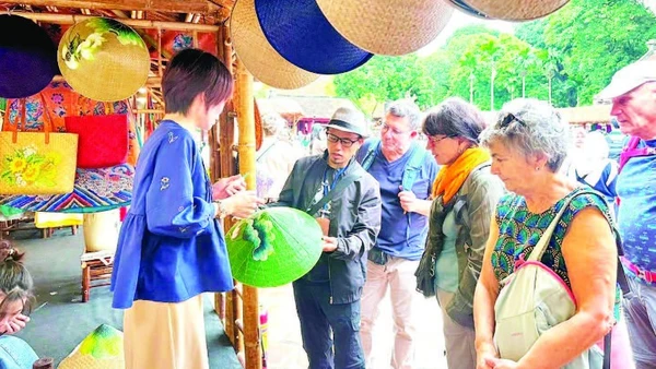 Khách quốc tế tìm hiểu sản phẩm thủ công mỹ nghệ tại Festival Thăng Long-Hà Nội.