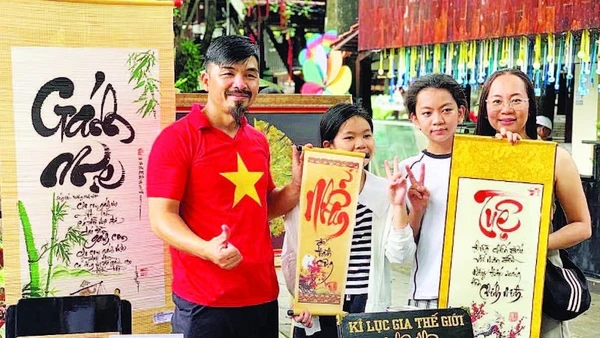 Nghệ nhân Võ Dương cho chữ tại gian hàng Ông đồ. (Ảnh Nhân vật cung cấp)