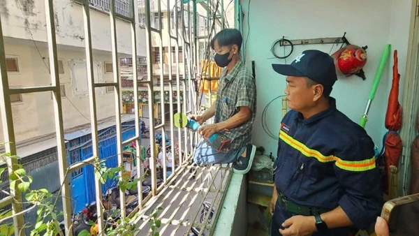 Cán bộ phòng cháy, chữa cháy giám sát việc cắt bỏ "chuồng cọp" tại một chung cư cũ trên địa bàn thành phố (Ảnh: HÀ KHÁNH)