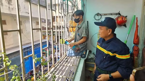 Cán bộ phòng cháy, chữa cháy giám sát việc cắt bỏ "chuồng cọp" tại một chung cư cũ trên địa bàn thành phố (Ảnh: HÀ KHÁNH)