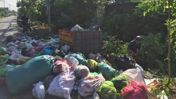 Người dân dọn dẹp một bãi rác tự phát gần bãi rác Đa Phước.