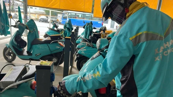 Các lái xe công nghệ bằng xe điện hai bánh sạc pin tại một cơ sở cung cấp dịch vụ sạc pin. 