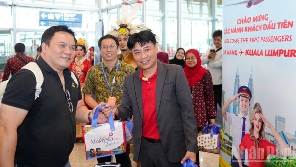 Ông Trần Hoàng Linh (phải), Giám đốc Văn phòng miền trung Vietjet đại diện hãng chào đón và tặng quà hành khách trên chuyến bay khai trương.