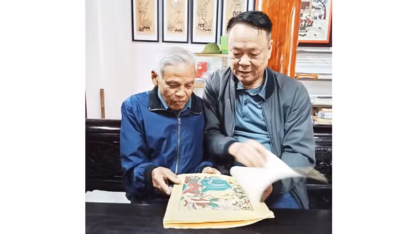Nghệ nhân Nguyễn Đăng Chế giới thiệu với tác giả bài viết bộ sưu tập tranh dân gian Đông Hồ.