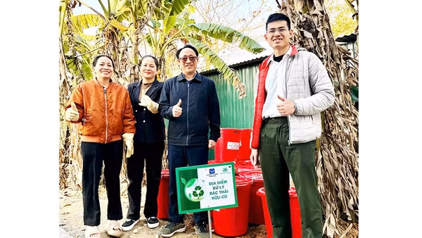 Trung úy Phạm Minh Hiếu (ngoài cùng bên phải) hướng dẫn người dân ủ rác hữu cơ thành phân bón vi sinh Bokashi.