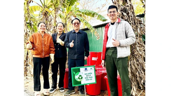 Trung úy Phạm Minh Hiếu (ngoài cùng bên phải) hướng dẫn người dân ủ rác hữu cơ thành phân bón vi sinh Bokashi.