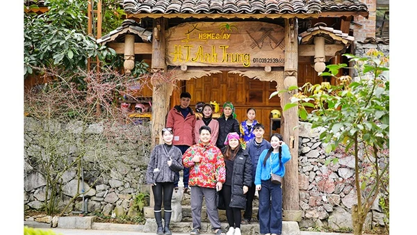 Anh Hiển (hàng dưới) chụp hình lưu niệm cùng du khách tại homestay của mình. 