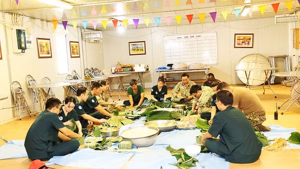Những người lính Việt Nam tại Phái bộ gìn giữ hòa bình LHQ ở Nam Sudan gói bánh chưng đón Tết. Ảnh: TIẾN PHÚC