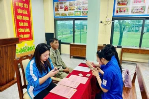 Đoàn viên thanh niên xã Cẩm Bình, tỉnh Hà Tĩnh hướng dẫn người dân làm hồ sơ trực tuyến.