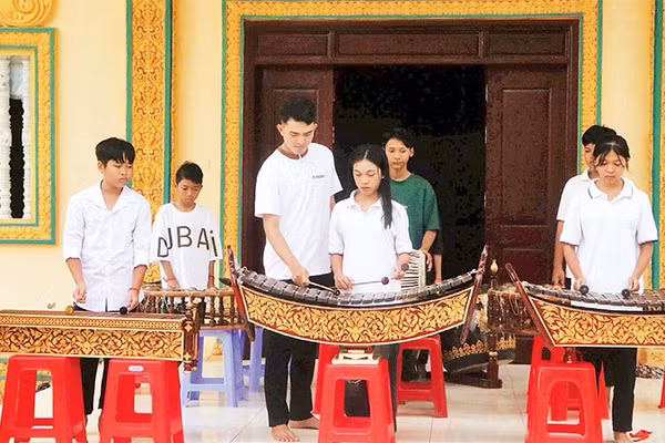 Anh Danh Nghiệp hướng dẫn các em chơi nhạc ngũ âm tại chùa Sóc Sâu.