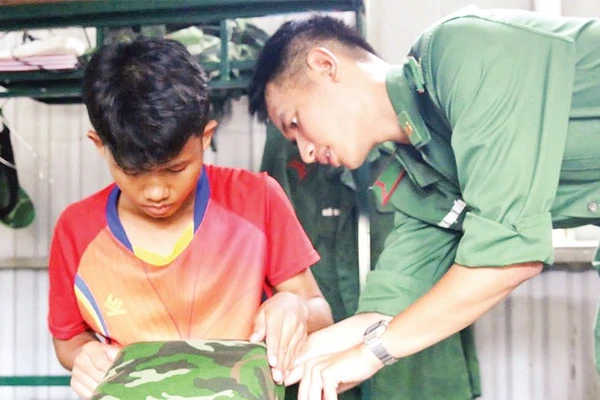 Hồ Lanh được chiến sĩ biên phòng hướng dẫn gấp chăn, gối trước khi về nội trú ở trường học mới.