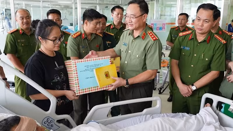 Thứ trưởng Phạm Thế Tùng động viên, tặng quà Đại úy Lê Đình Công.
