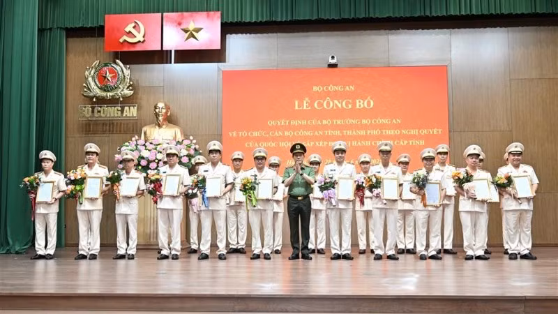 Bộ trưởng Lương Tam Quang trao Quyết định và tặng hoa chúc mừng các đồng chí Giám đốc Công an địa phương sau sáp nhập.