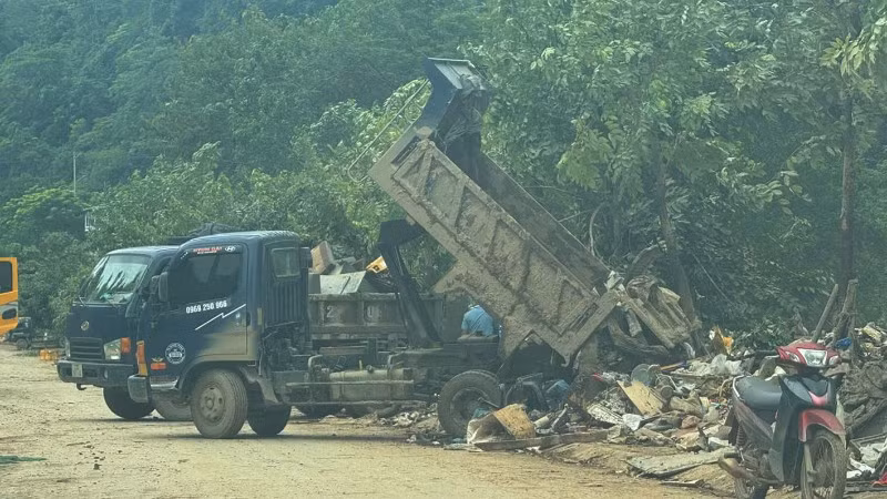 Xe chở chất thải được thu gom từ những tuyến đường bị ngập úng đổ trên vỉa hè đường Phùng Hưng, phường Hà Giang 2.