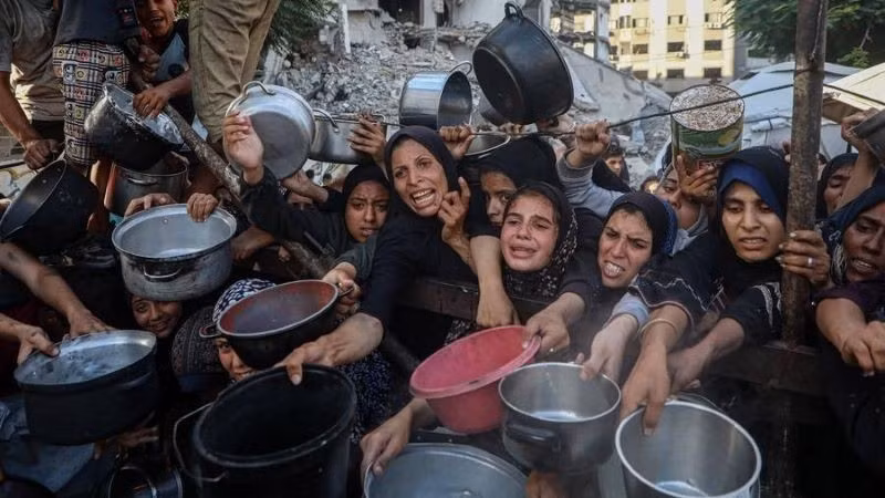 Người dân Palestine phải di dời chờ nhận thực phẩm miễn phí từ một trung tâm phân phối thực phẩm ở thành phố Gaza, ngày 14/7/2025.(Ảnh: THX)