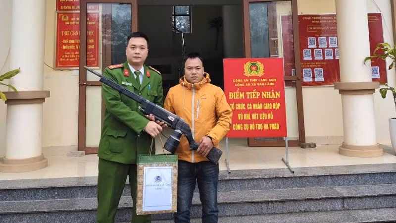 Công an xã Văn Lãng tặng quà và thư khen cho người dân giao nộp vũ khí tại trụ sở.