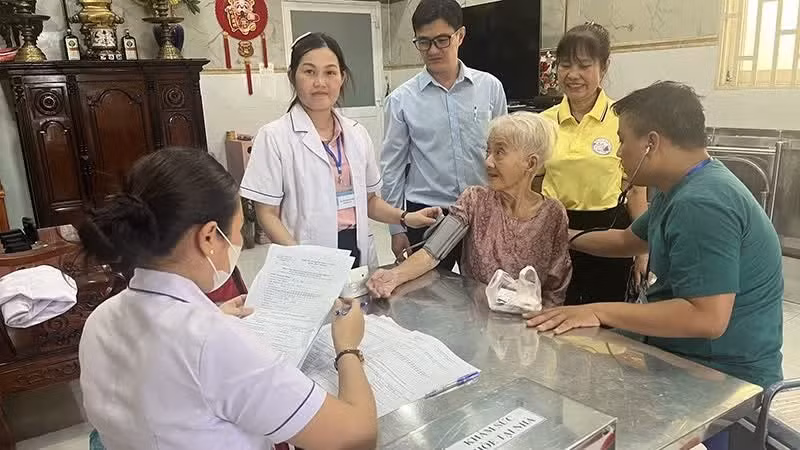 &ldquo;Đội phản ứng nhanh&rdquo; phường Minh Phụng (Th&agrave;nh phố Hồ Ch&iacute; Minh) kh&aacute;m sức khỏe tại nh&agrave; cho b&agrave; L&ecirc; Thị Đời - 81 tuổi, đối tượng yếu thế. (Ảnh: MINH ANH)