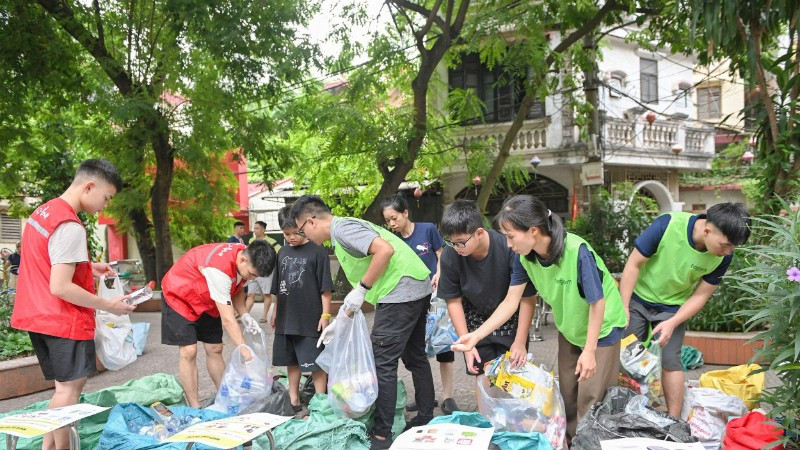 Các thành viên Tagom hướng dẫn người dân cách phân loại rác. (Ảnh THẾ ĐẠI)