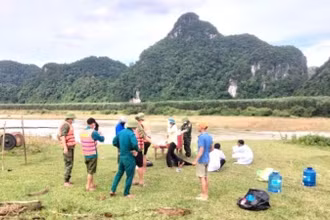 Lực lượng chức năng và gia đình tìm thấy thi thể 1 phụ nữ bị lũ cuốn ở xã Tân Hóa.