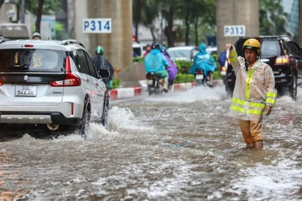 Cán bộ Phòng Cảnh sát giao thông, Công an TP Hà Nội điều tiết giao thông tại các điểm ngập sâu. (Ảnh: Văn Huế)