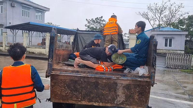 Lực lượng chức năng xã Điện Bàn Tây vận chuyển người bị nạn qua vùng ngập lũ để đi cấp cứu.